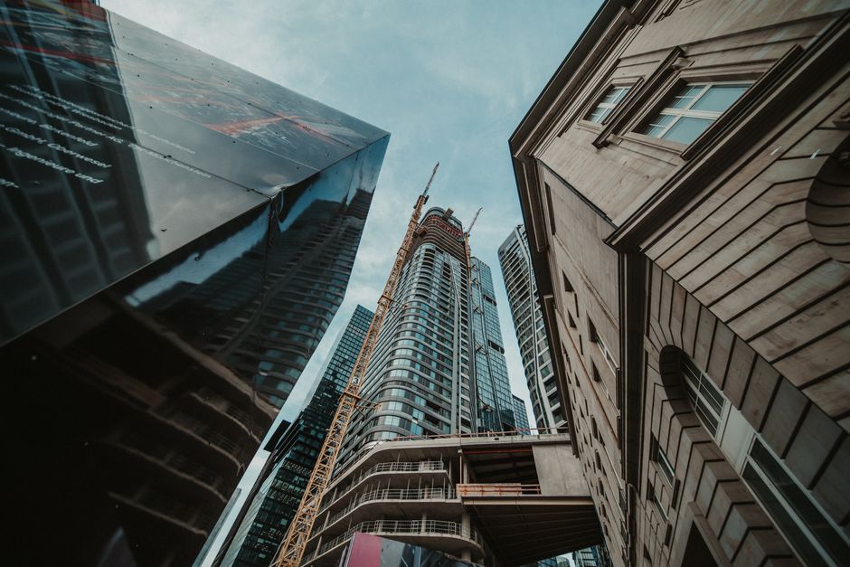 Upward view of modern skyscrapers in an urban setting with architectural diversity.